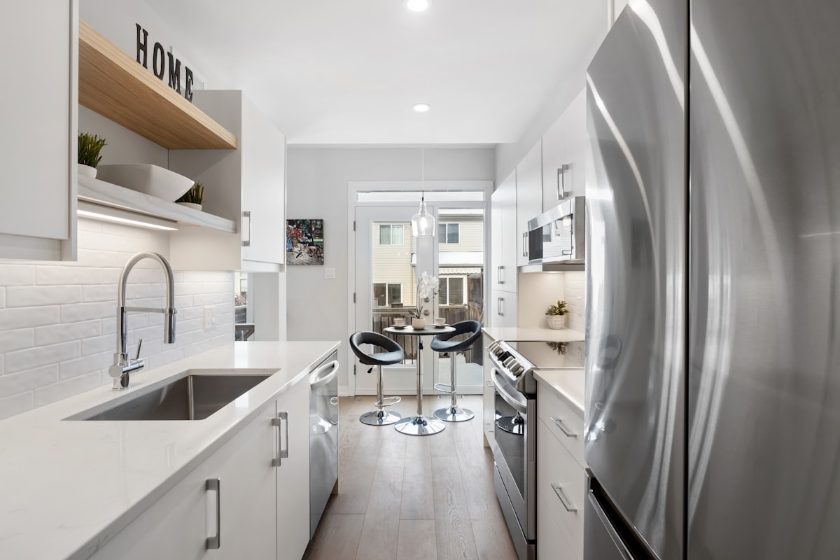 Modern kitchen with freshly refaced white shaker cabinets and brushed gold hardware