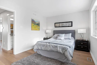 A peaceful bedroom with a modern bed frame, neatly arranged wardrobe, and calming neutral tones.