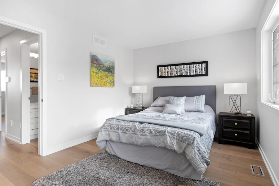 Chambre lumineuse avec un lit, des tables de chevet et un tableau