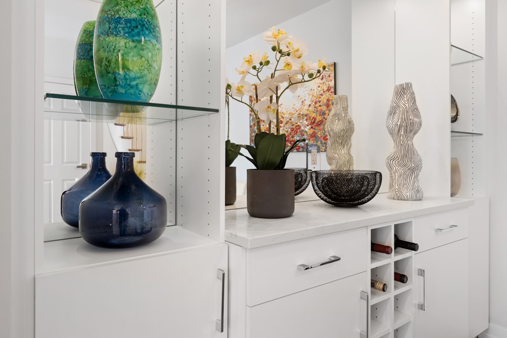a white shelf filled with vases and other decorative items