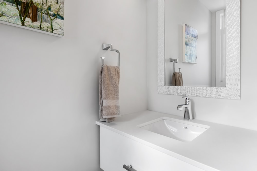 a bathroom with a sink, mirror and towel rack