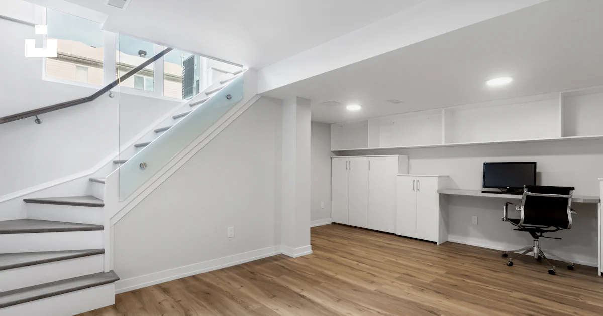 An empty room with a desk, computer, and stairs photo – Free Interior ...