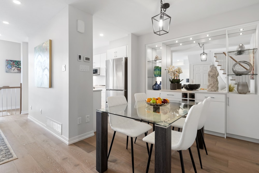 a dining room with a glass table and white chairs