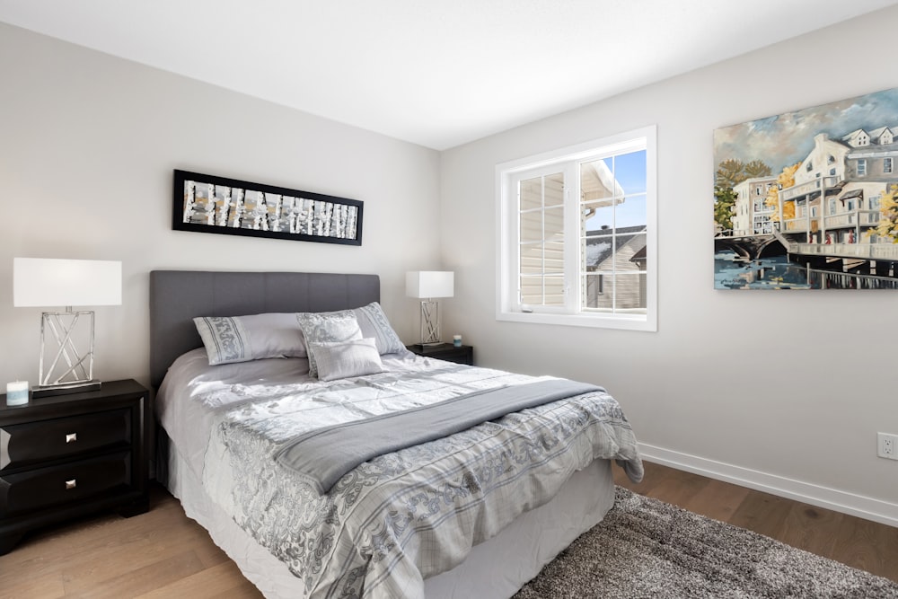 a bedroom with a large bed and a painting on the wall