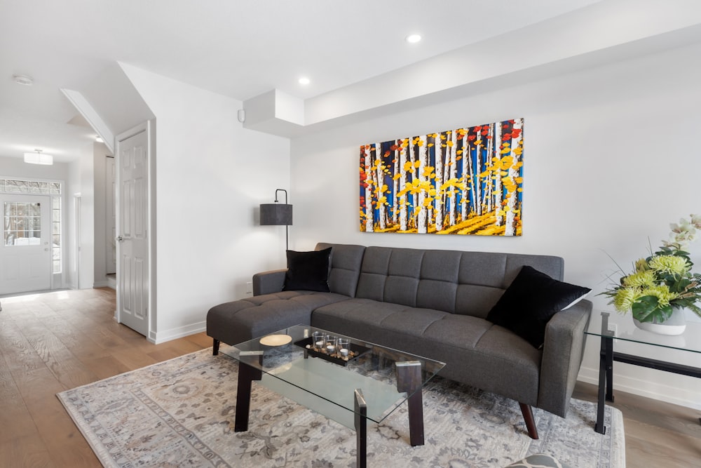 a living room filled with furniture and a painting on the wall