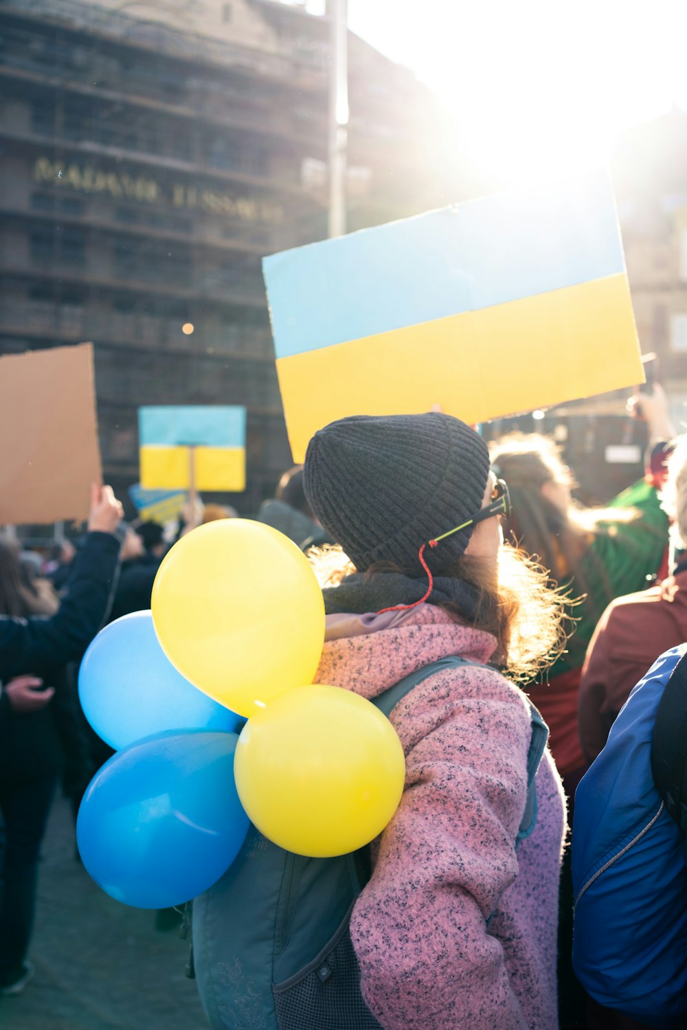 a person holding a bunch of balloons in a crowd