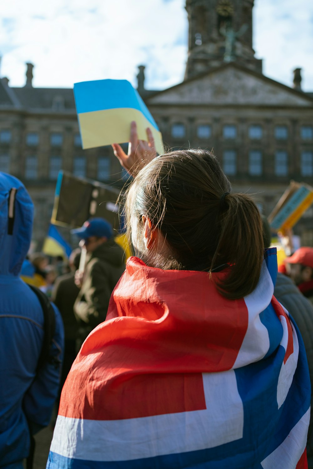 Foto Una mujer con chaqueta roja, blanca azul sostiene una – Imagen Países bajos en Unsplash