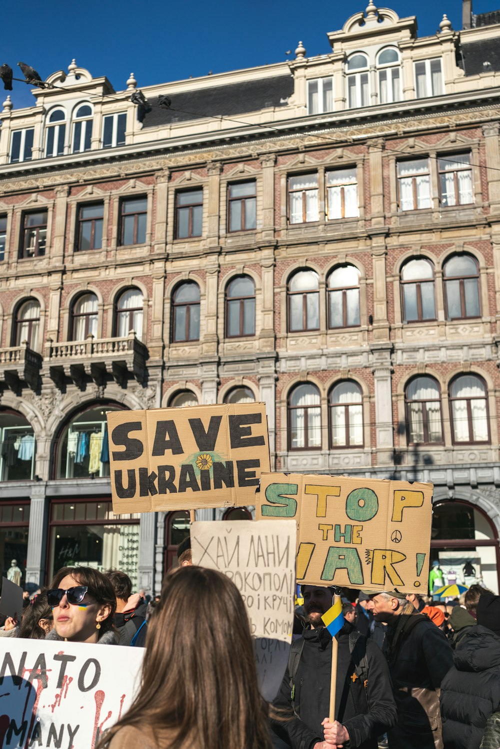 a group of people holding signs in front of a building