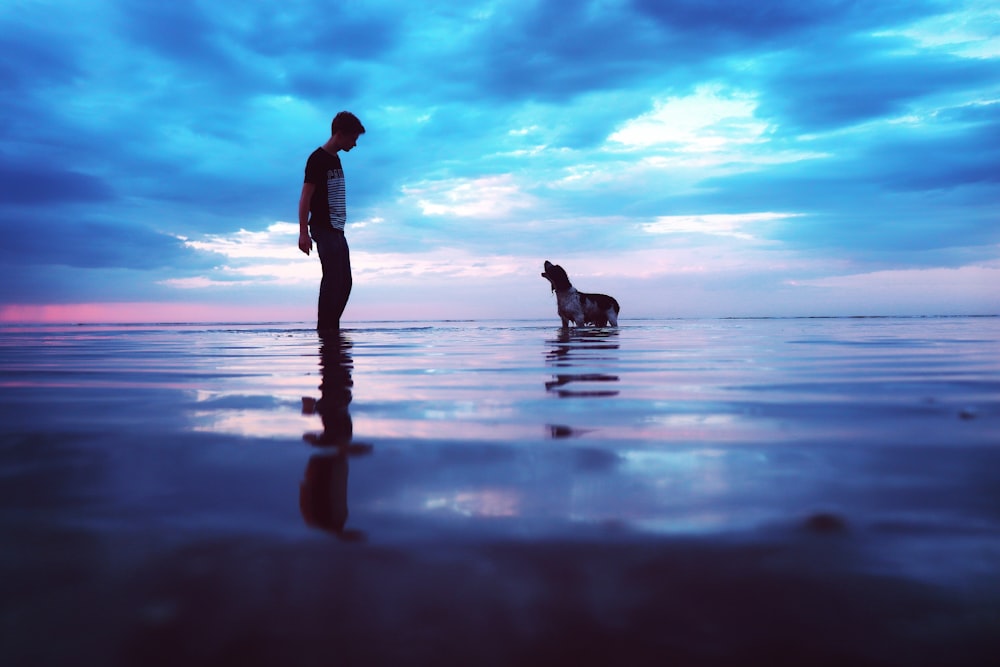 a man and his dog are standing in the water