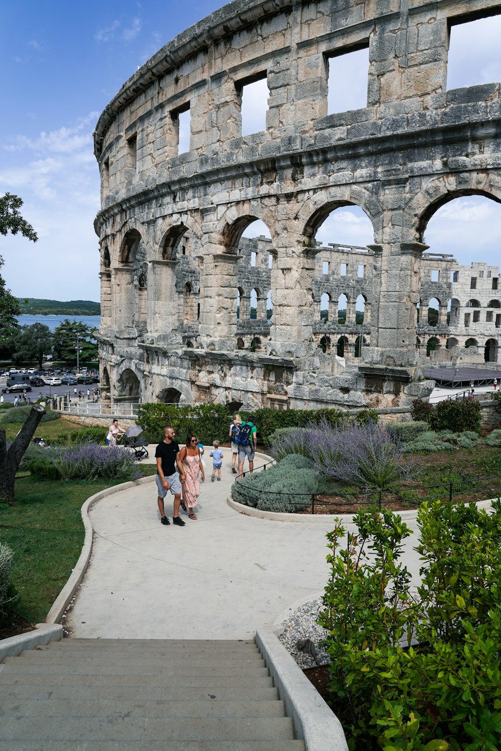 a group of people walking down a walkway next to an old building