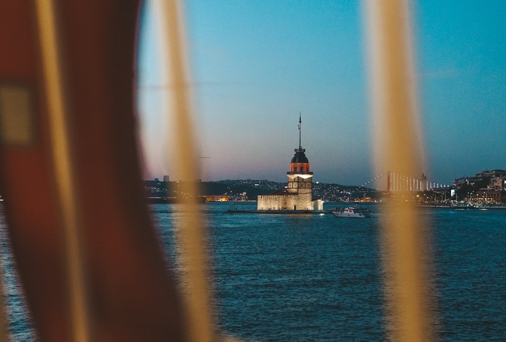 ein großes Gewässer mit einem Glockenturm im Hintergrund