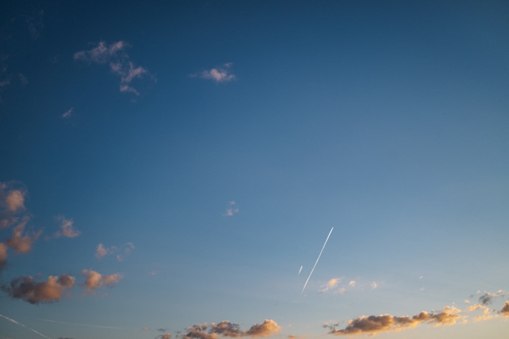 a plane is flying in the sky at sunset