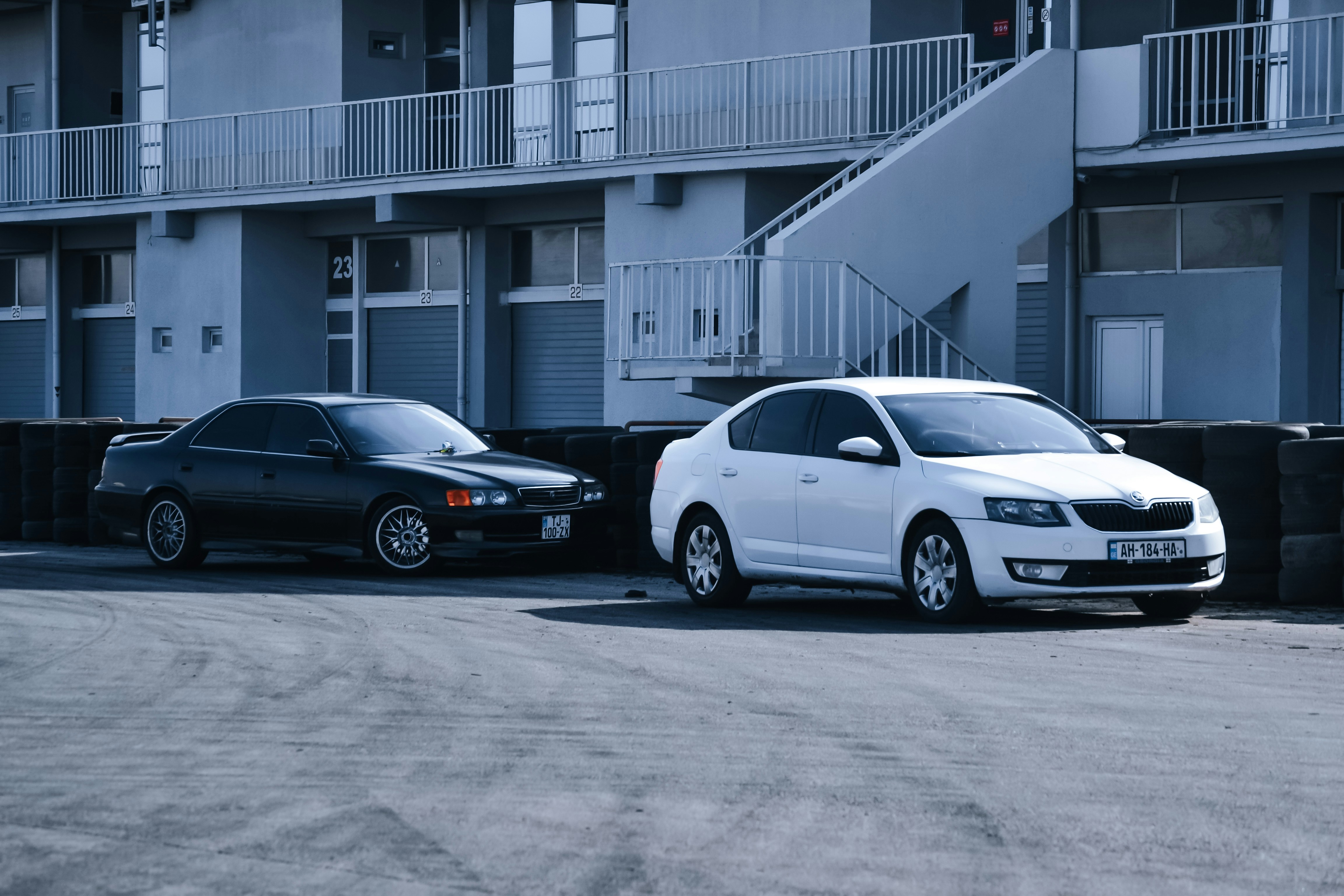 two cars parked next to each other in front of a building