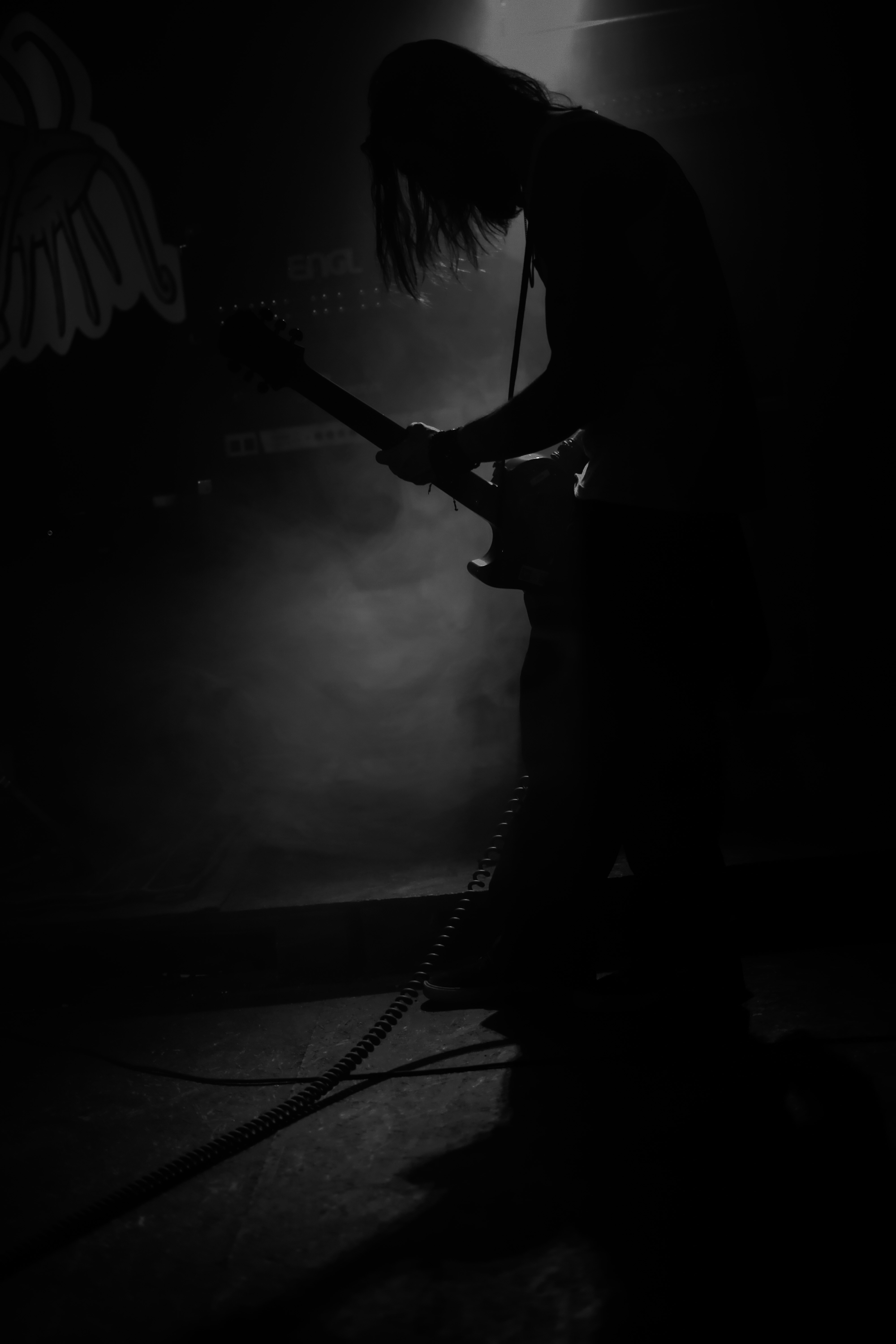 Una foto en blanco y negro de una persona tocando una guitarra