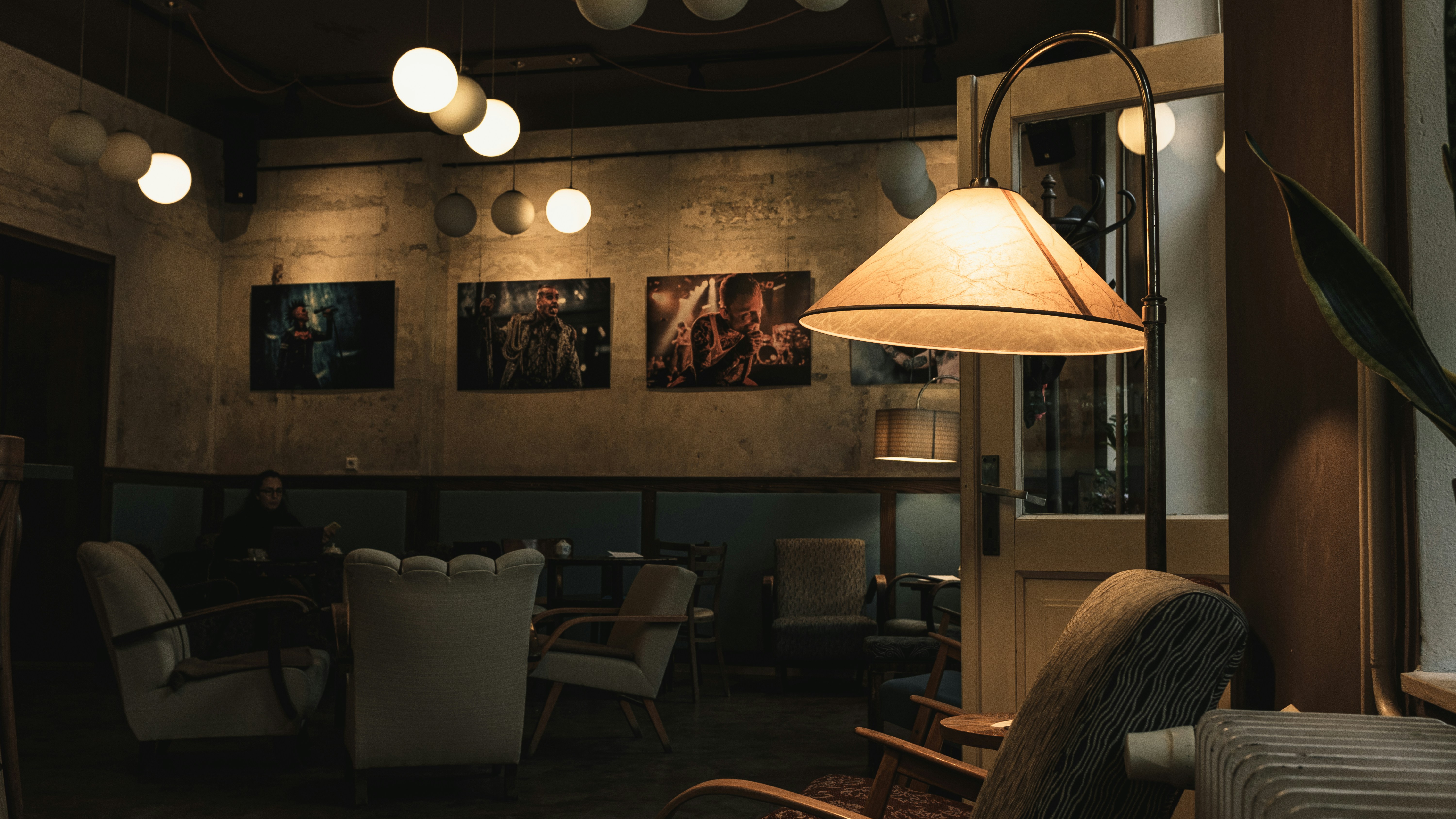 a dimly lit room with chairs and a lamp