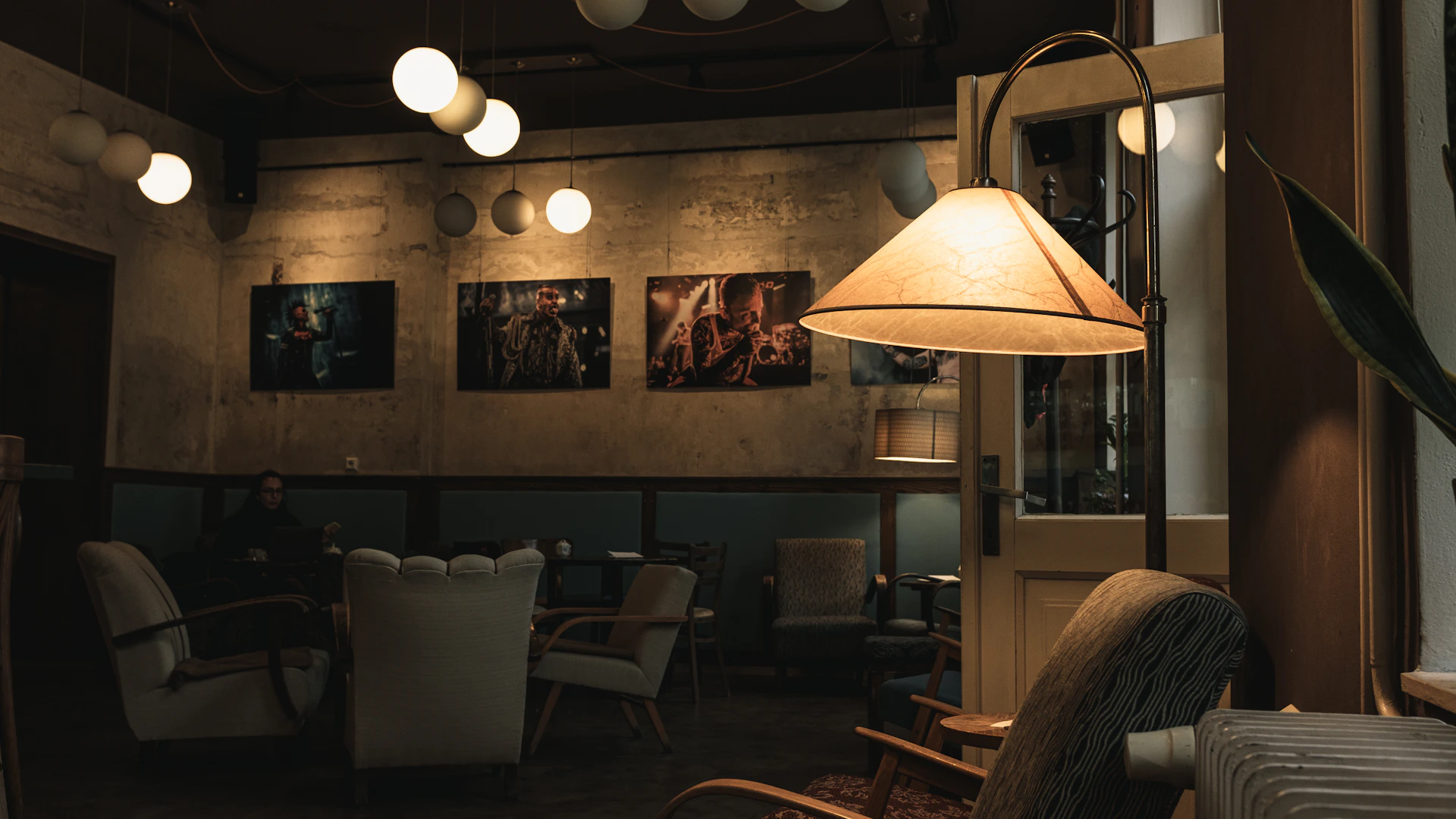 a dimly lit room with chairs and a lamp