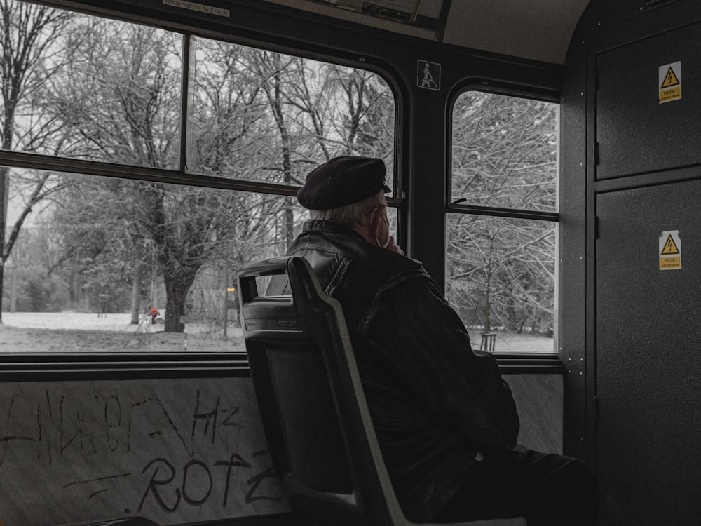 a man sitting on a bus looking out the window