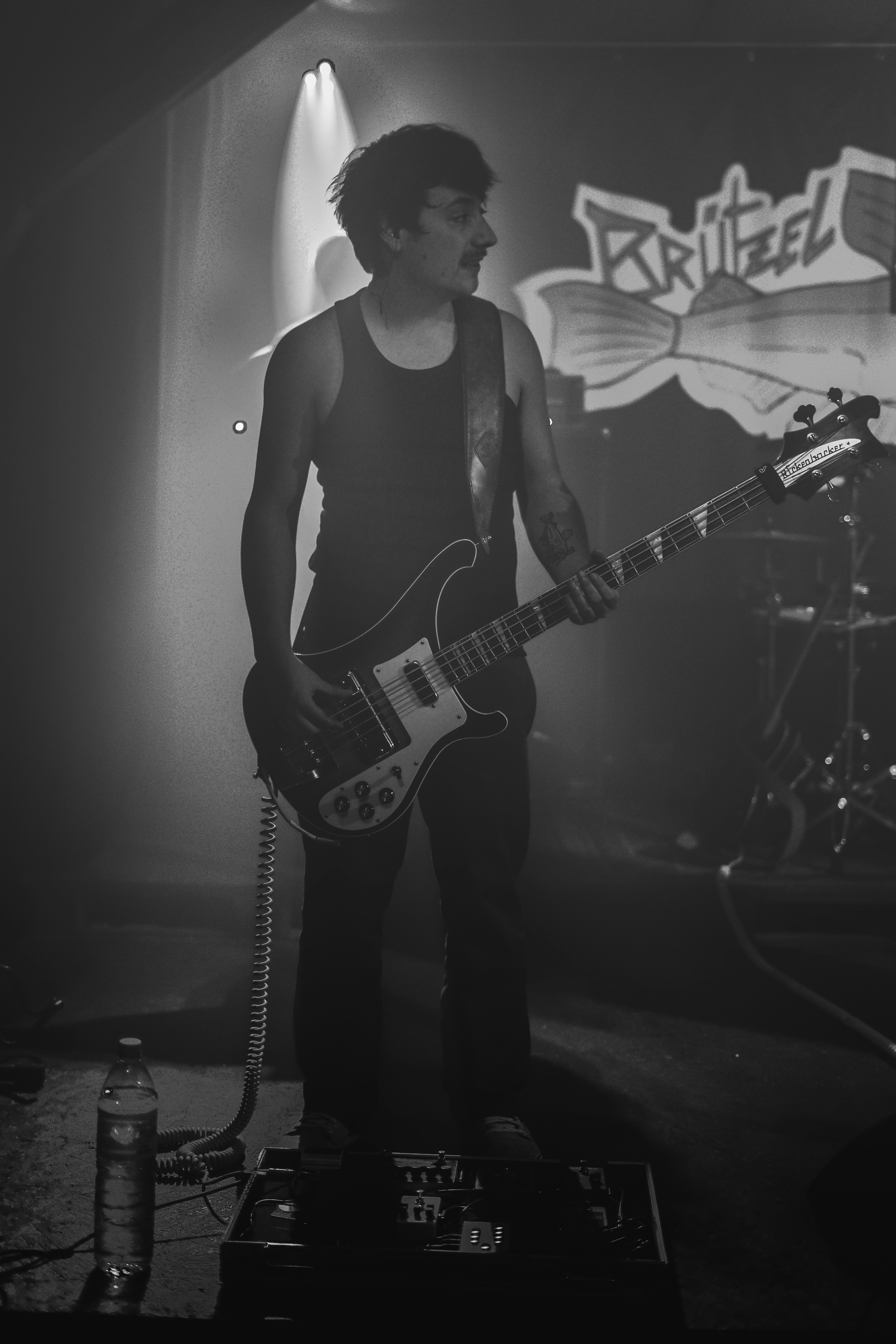 Un hombre parado en un escenario con una guitarra