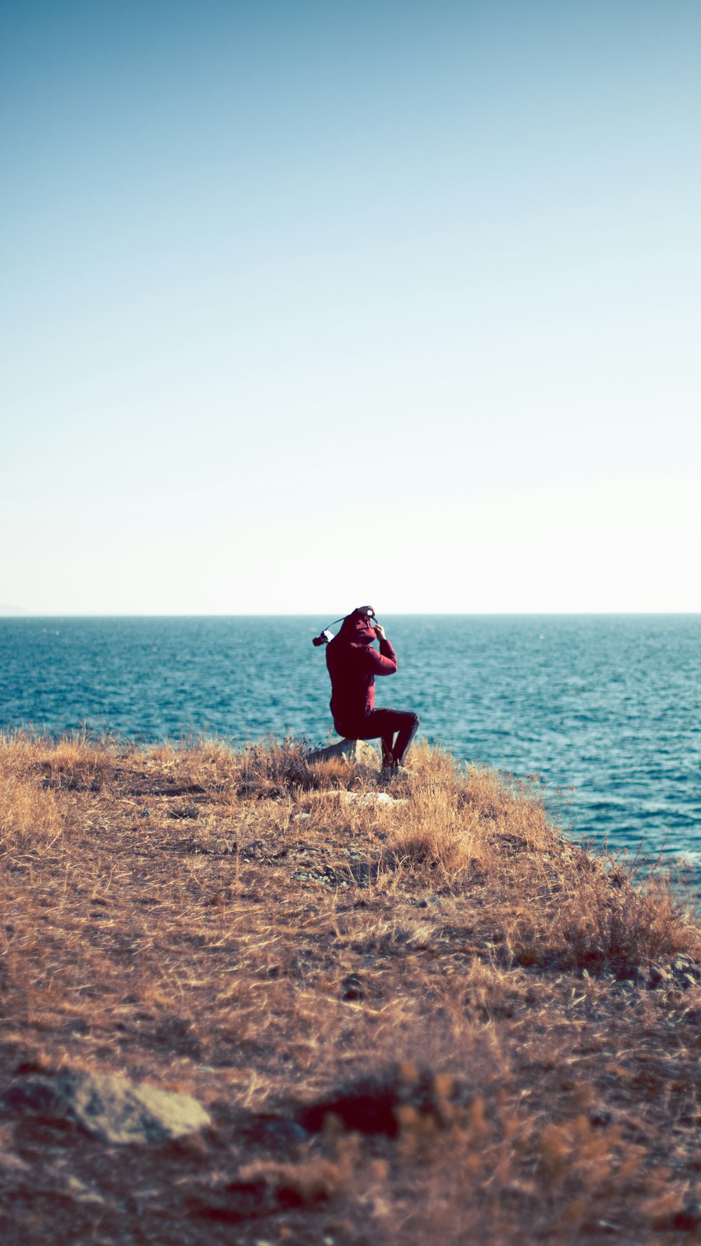 a person sitting on a cliff overlooking the ocean