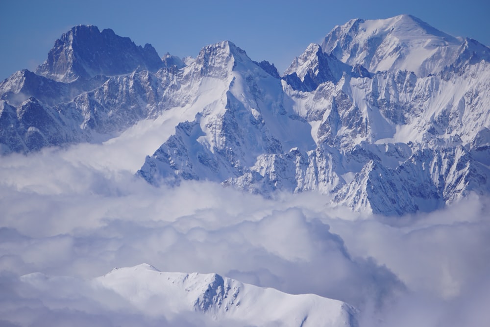 a mountain range covered in snow and clouds