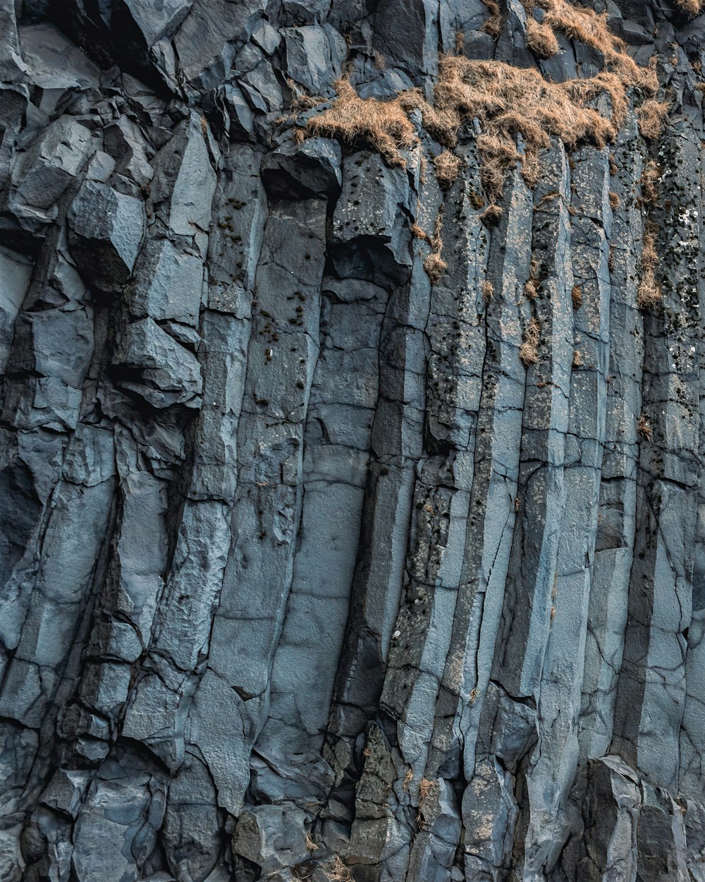 a large rock formation with grass growing on top of it