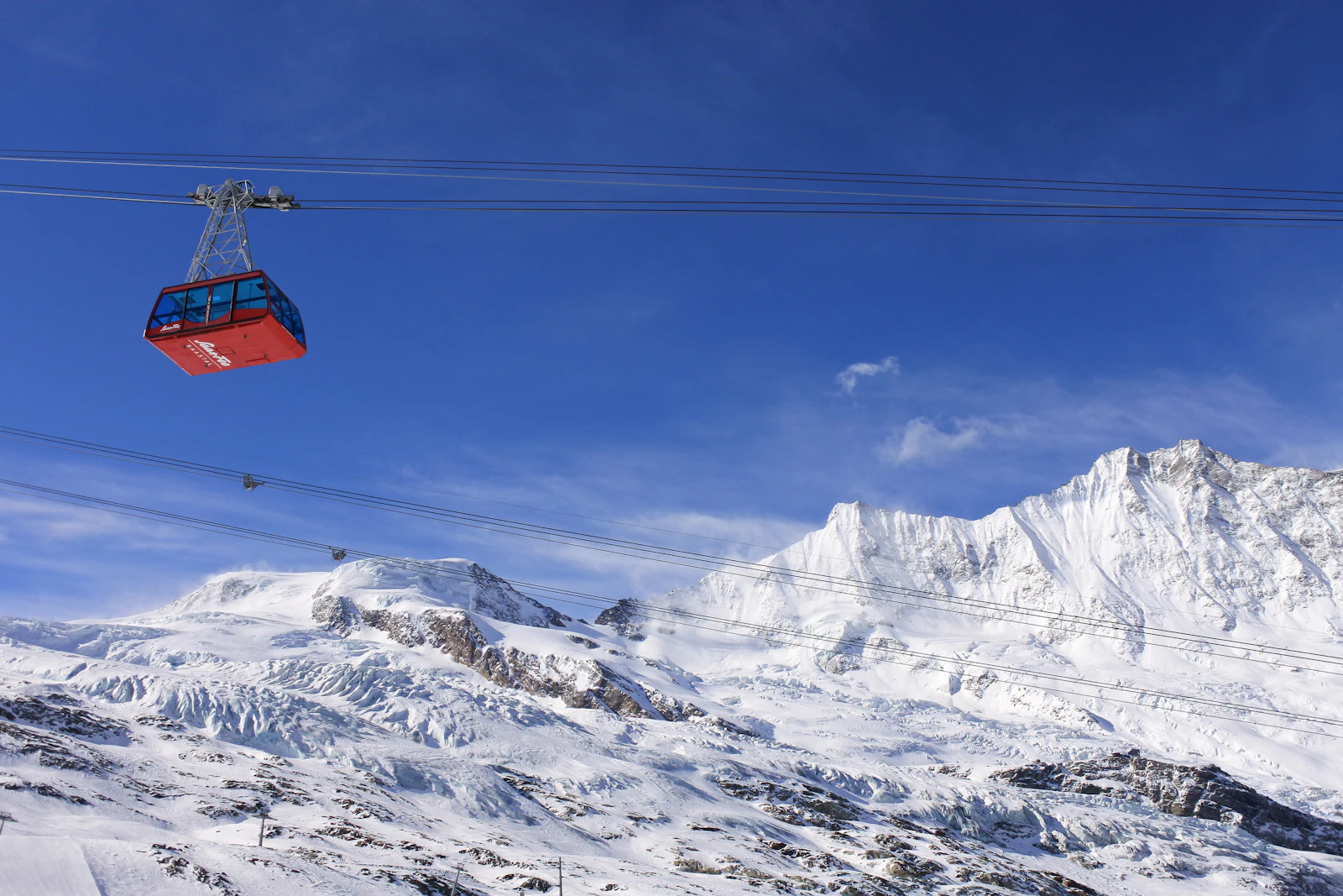 A ski lift climbing a snow-covered mountain near Saas-Fee in winter