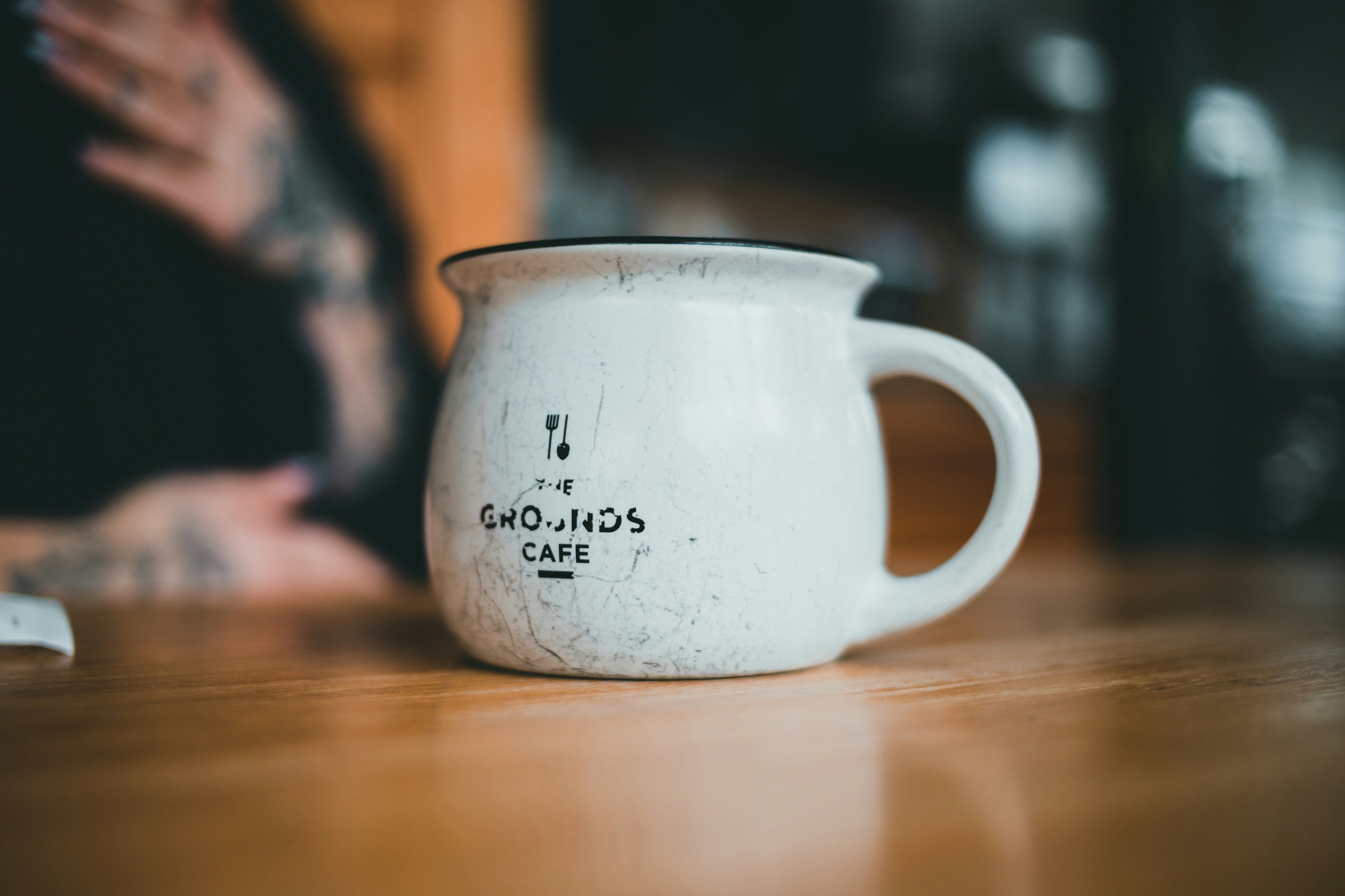 a white coffee mug sitting on top of a wooden table