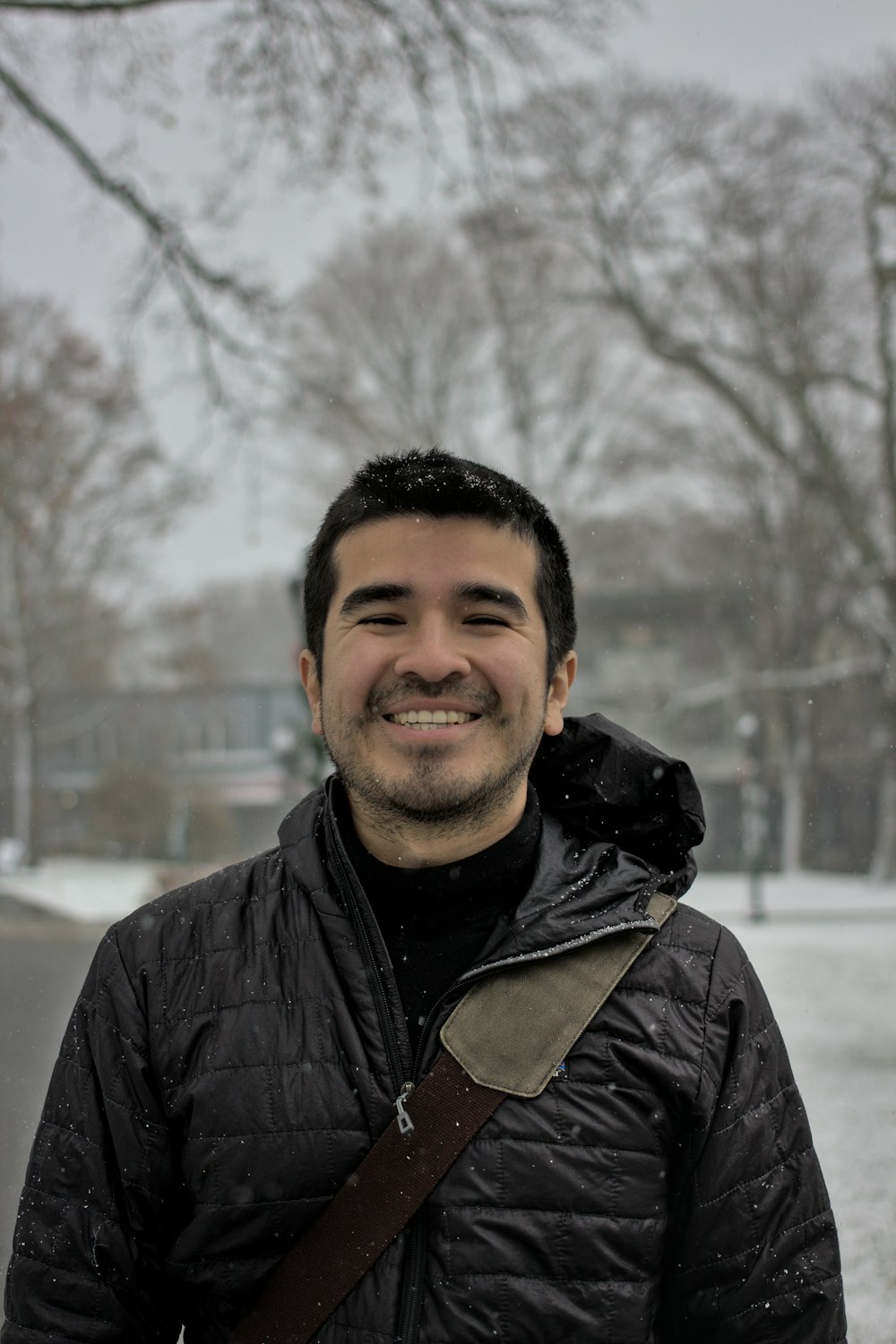 a man standing in the snow smiling for the camera