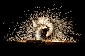 A dynamic scene with a person surrounded by swirling sparks of light, creating an effect of a glowing circle against a dark background.