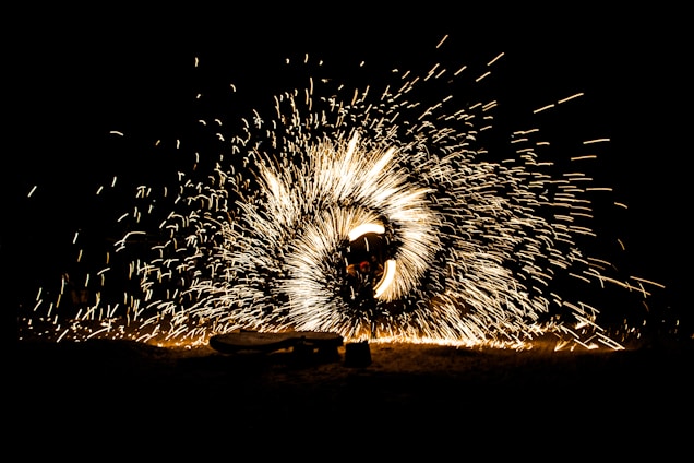 A dynamic scene with a person surrounded by swirling sparks of light, creating an effect of a glowing circle against a dark background.