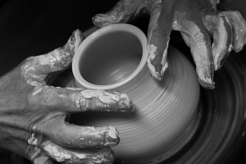 a person is making a vase on a potter's wheel