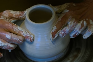 a person is making a vase on a potter's wheel