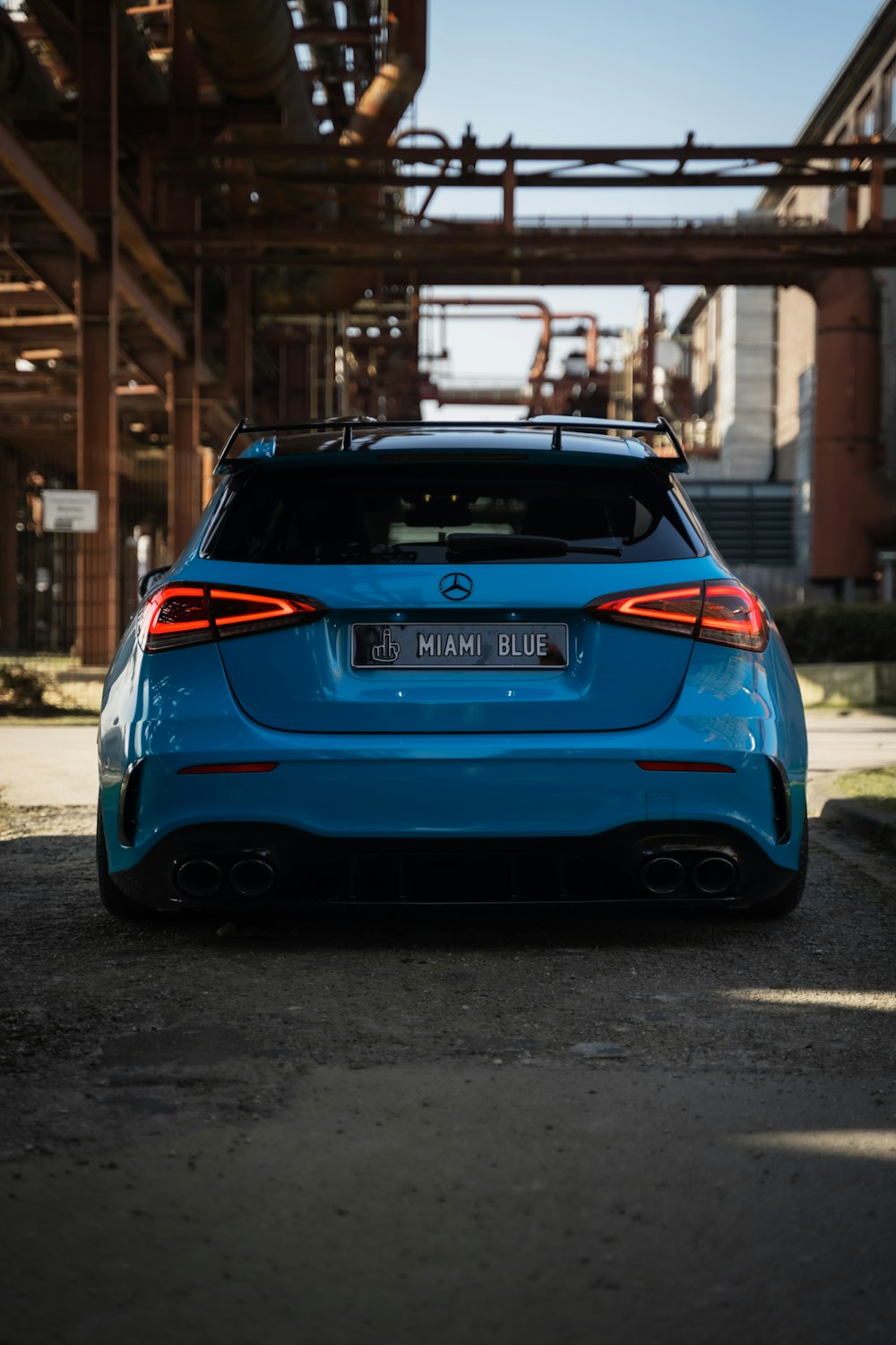 a blue car parked in front of a factory