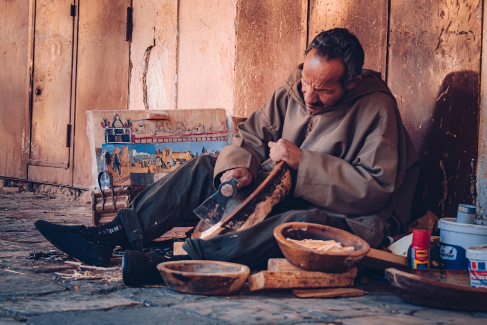 a man sitting on the ground working on something