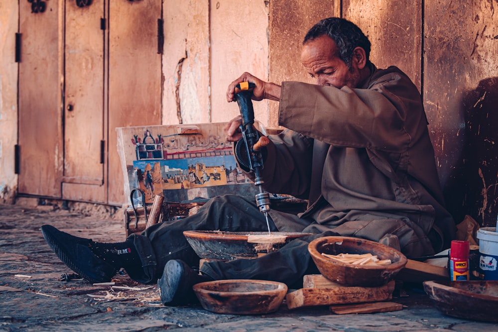 a man sitting on the ground working on something