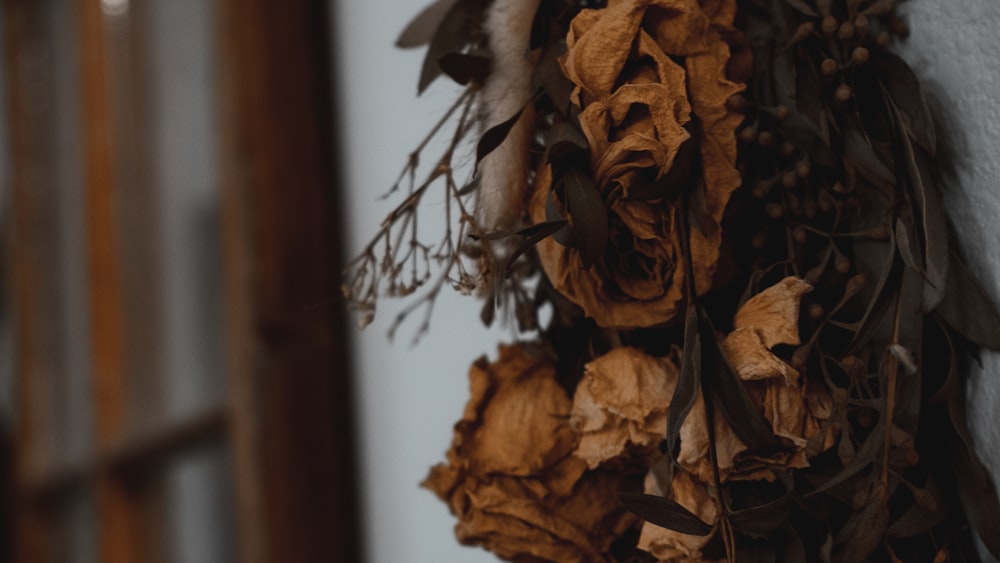 dried flowers hang on a wall near a door