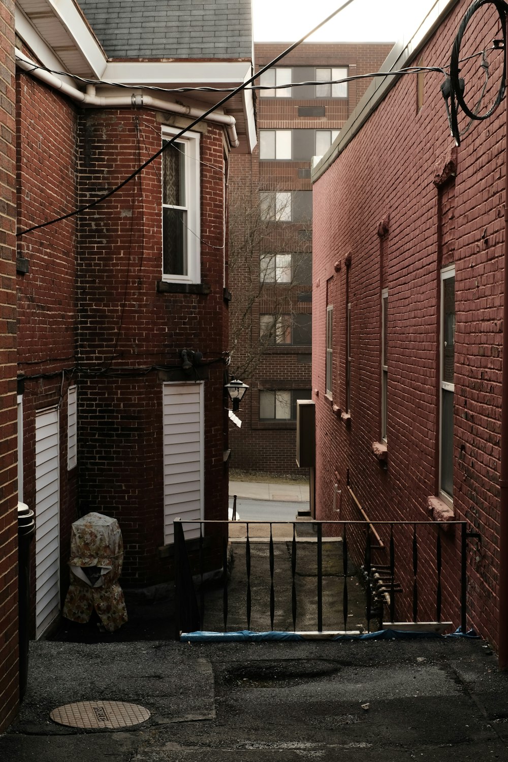 an alley way with a gate and a chair