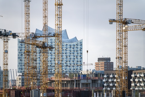 a group of cranes that are next to a building