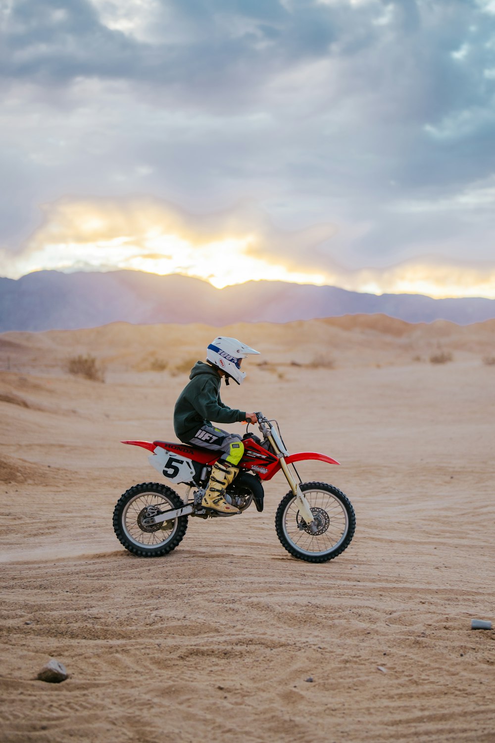 a man riding a dirt bike on top of a sandy field