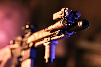 a close up of a rifle with a purple light in the background