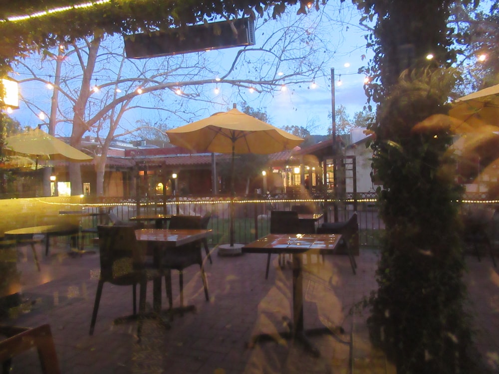 a restaurant with tables and umbrellas outside at night