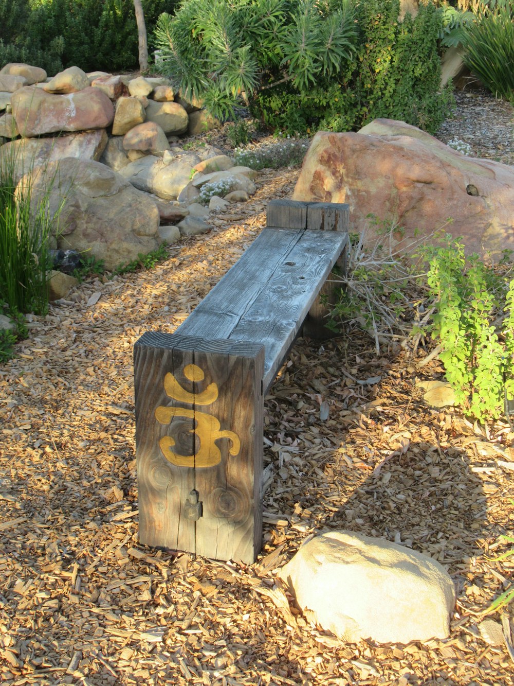 a wooden bench sitting in the middle of a garden