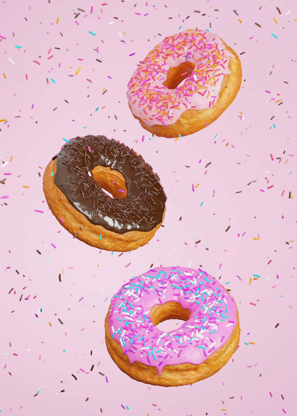 three donuts with pink frosting and sprinkles on a pink background