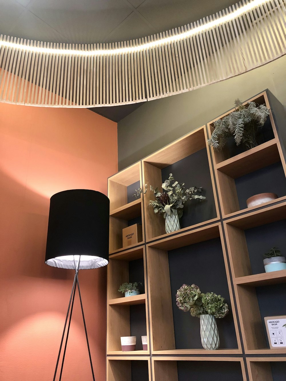 a living room with a lamp and a book shelf