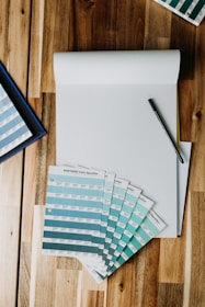 A color palette and typography guide laid out neatly beside a branded notebook and pen.