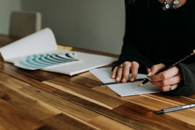 A designer sketching new eco-conscious fashion designs on recycled paper.
