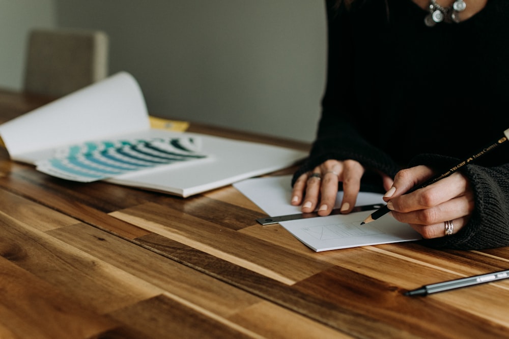 a woman sitting at a table with a pen and paper