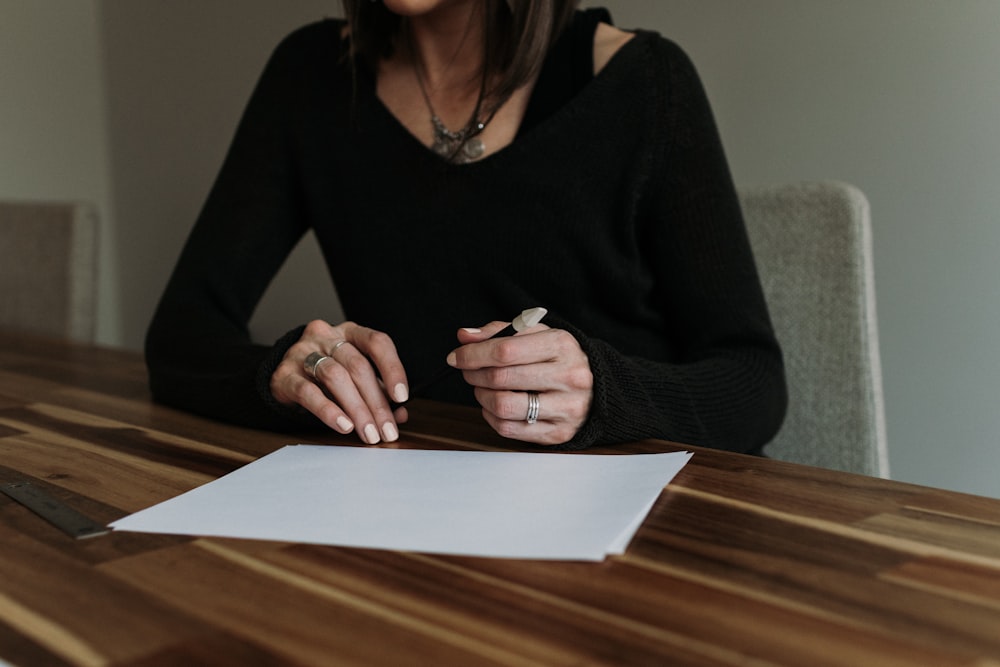 a woman sitting at a table with a piece of paper