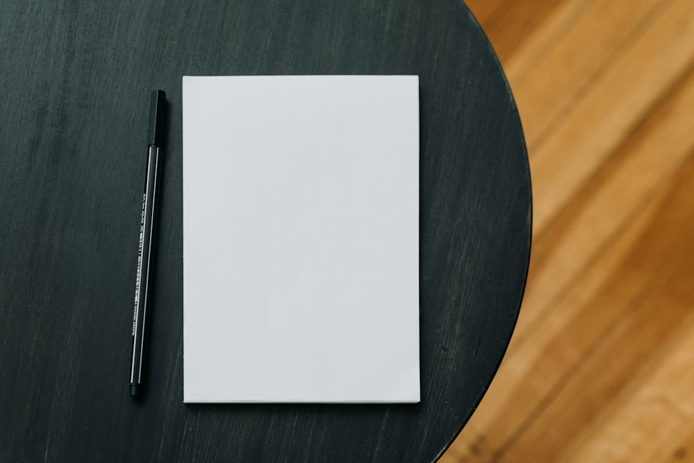 a notepad and a pen on a wooden table