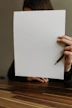 a woman holding a piece of paper and a pencil
